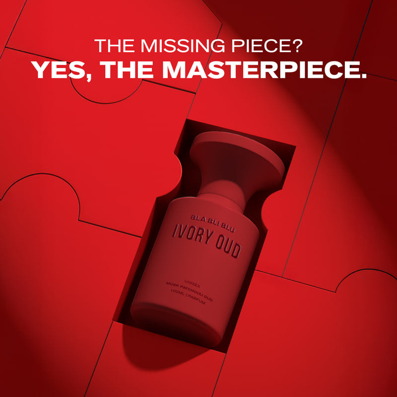 Red perfume bottle labeled 'IVORY OUD' on a red background with text 'THE MISSING PIECE? YES, THE MASTERPIECE.'